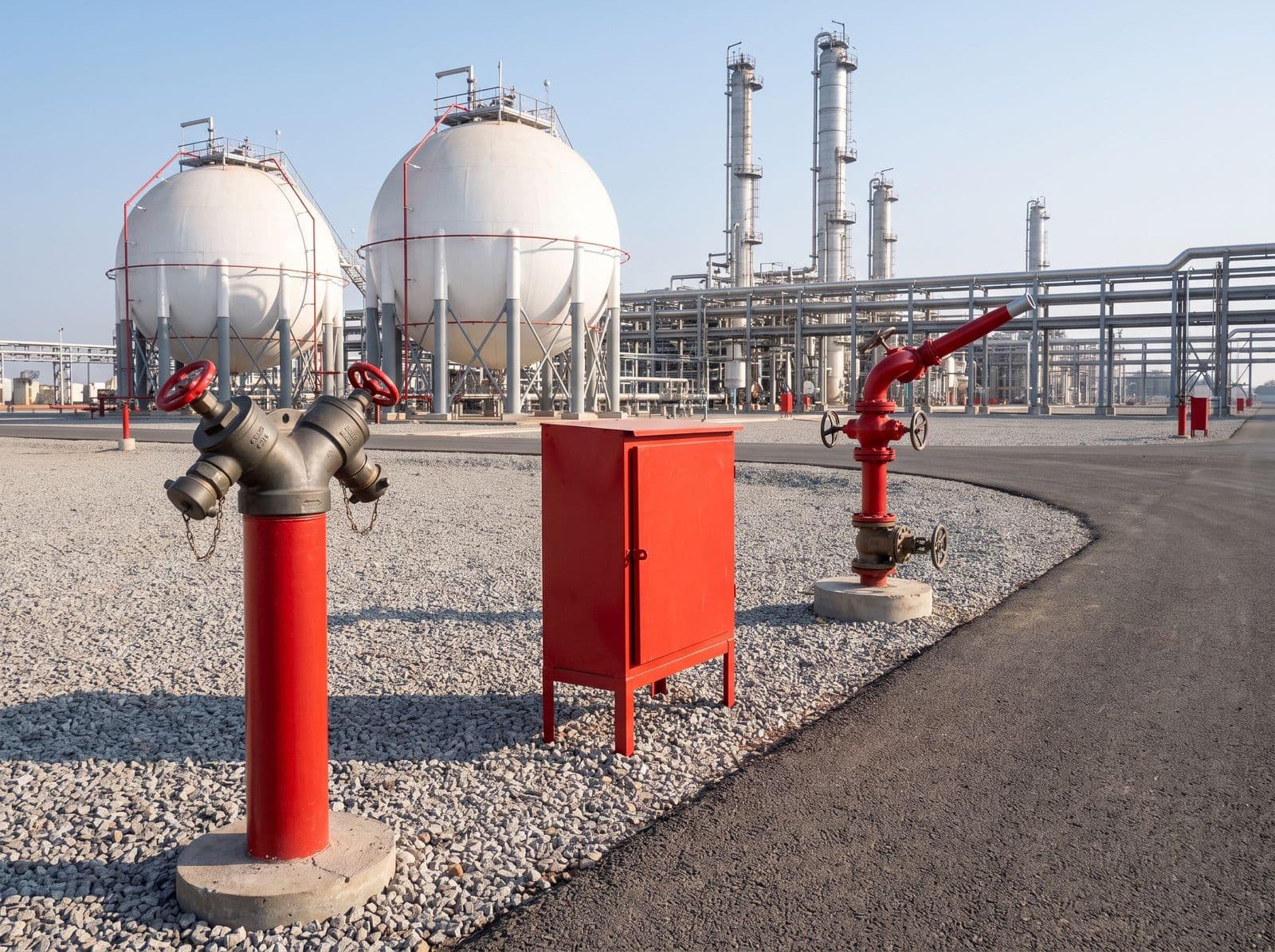 Stand-post hydrant, hose box and water monitor beside a road at an LPG plant with Horton spheres